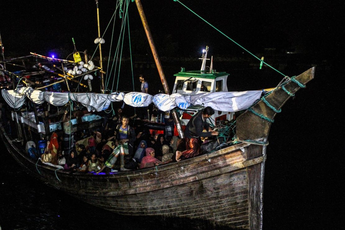 In this file photo, Rohingya refugees sit on a wooden boat as Indonesian officials conduct an evacuation at the Krueng Geukueh port in Lhokseumawe, Aceh, Indonesia, Dec. 31, 2021. 