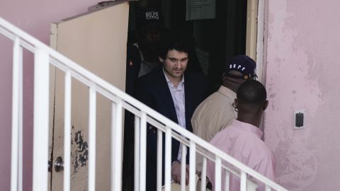 Sam Bankman-Fried is escorted out of court following a hearing in the Bahamas on Monday. 