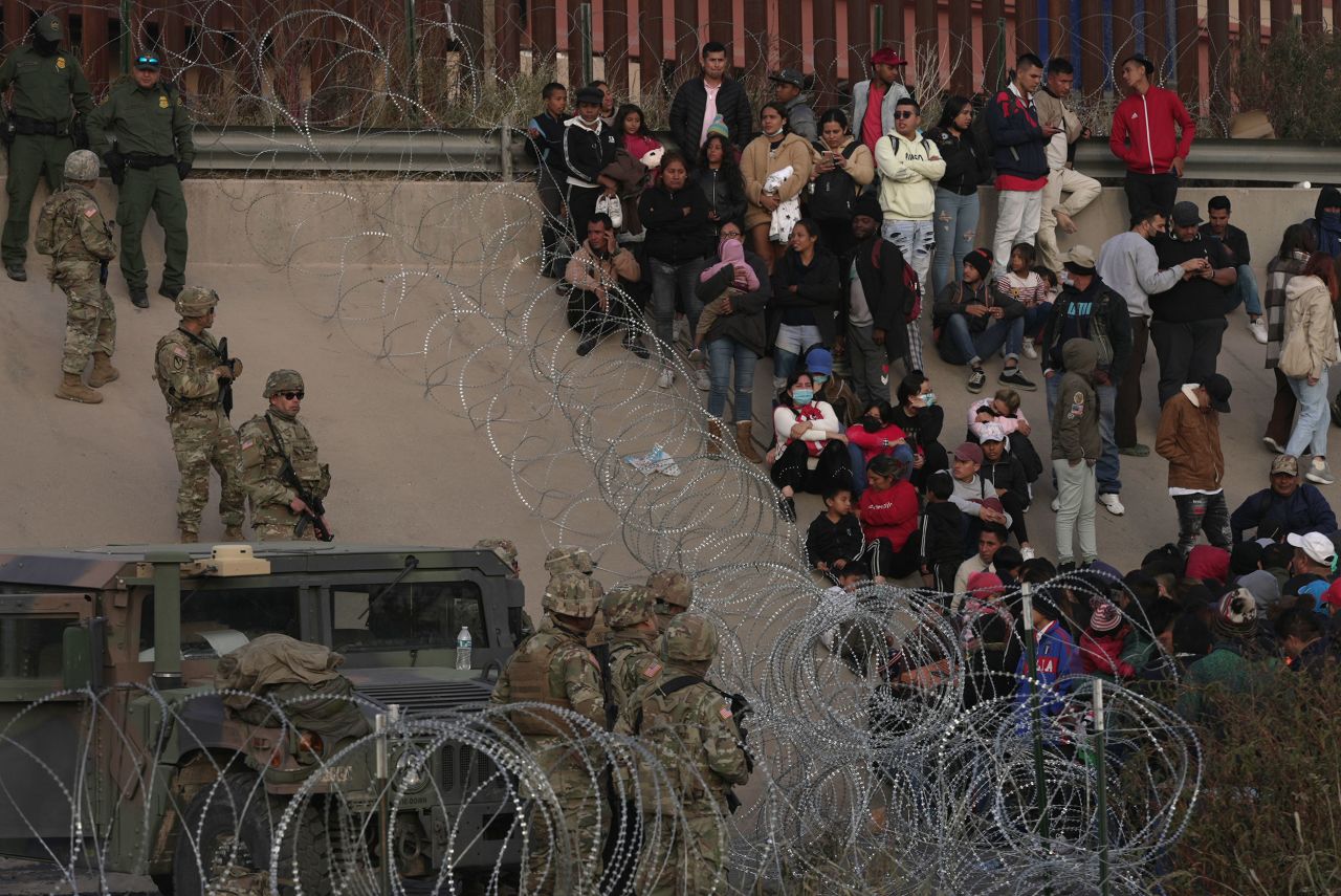 A group of migrants wait on the US side of the Rio Grande after the Texas National Guard blocked access to parts of the border on December 20.