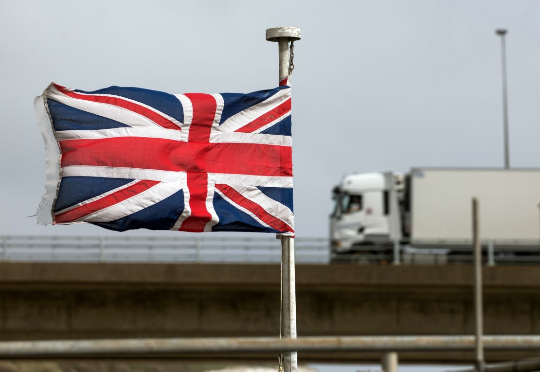A truck passes a Union Jack, at the Port of Dover on April 1, 2021. The UK government has delayed post-Brexit checks on EU food imports until the end of 2023. 