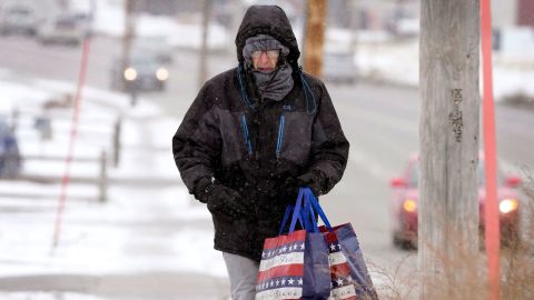 Greg Behrens จากเมืองดิมอยน์ รัฐไอโอวา พยายามทำตัวให้อบอุ่นขณะเดินบนทางเท้าที่ปกคลุมไปด้วยหิมะ วันพุธที่ 21 ธันวาคม 2022 ในเมืองดิมอยน์ รัฐไอโอวา