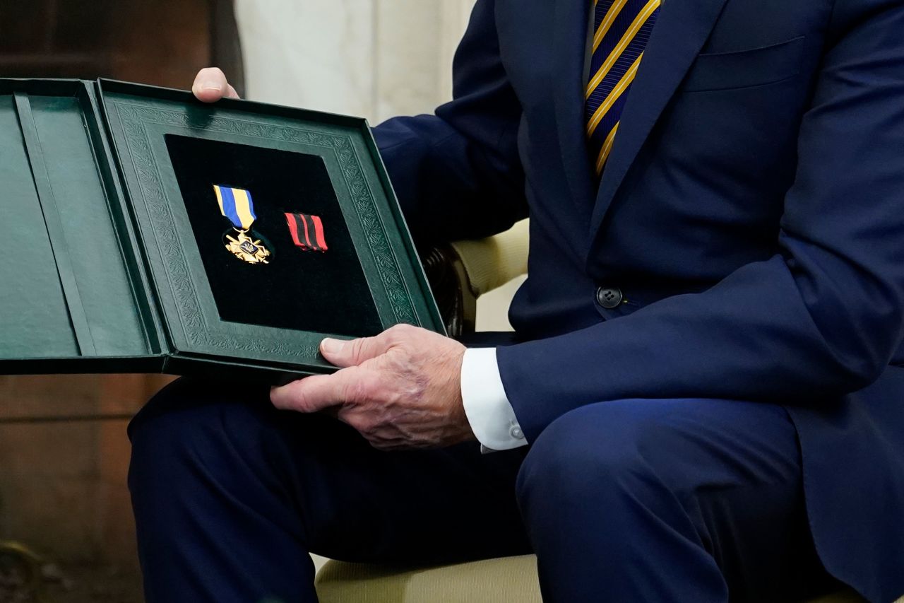 Biden holds the Cross of Combat Merit. "He's very brave," Zelensky said of the soldier. "And he said give it to very brave President, and I want to give you, that is a cross for military merit."