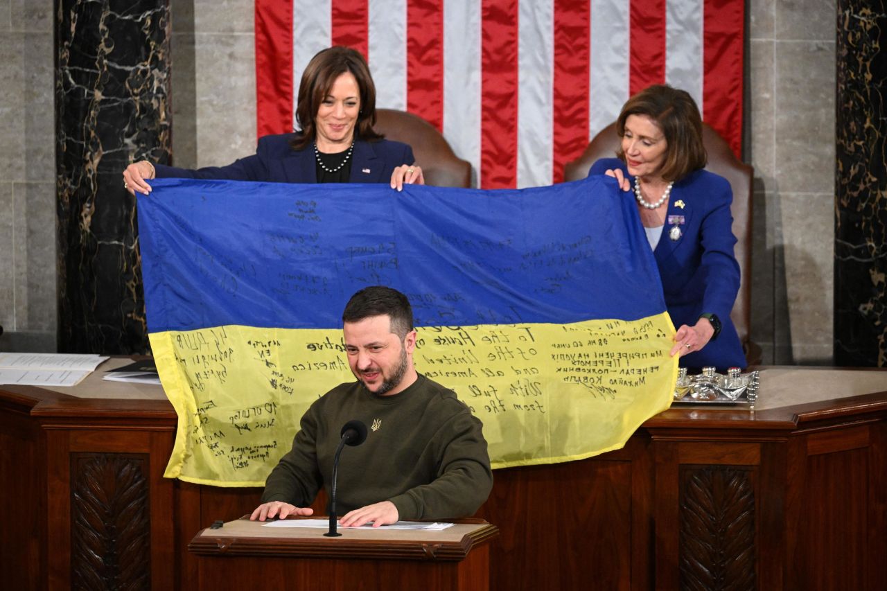 President Volodymyr Zelensky addresses Congress as Rep. Nancy Pelosi and Vice President Kamala Harris hold up a Ukrainian national flag signed by Ukrainian soldiers at the Capitol in Washington on Wednesday, December 21.