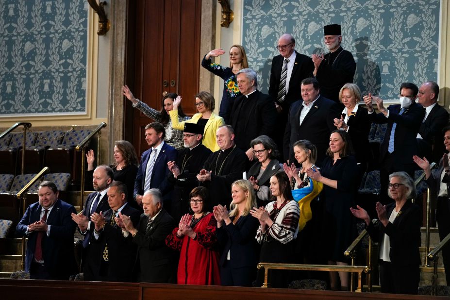 Guests of the the Ukrainian delegation wave as Zelensky acknowledges them during his address.