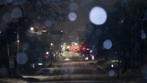 Cars move along Burlington Street as snow falls during a blizzard warning Wednesday in Iowa City, Iowa.