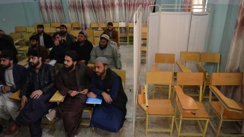 Male students attend a class behind a curtain meant to separate men from women at a university in Kandahar province, Afghanistan, December 21, 2022.