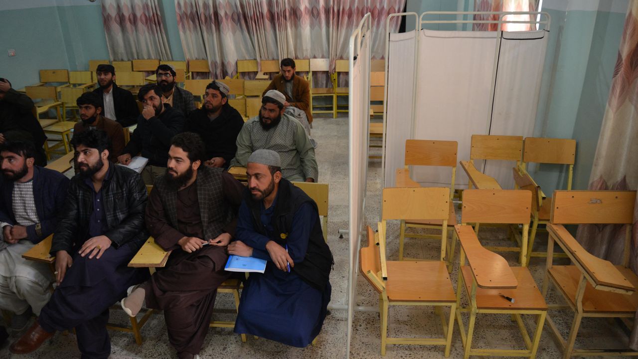 Male students attend a class behind a curtain meant to separate men from women at a university in Kandahar province, Afghanistan, on December 21, 2022.