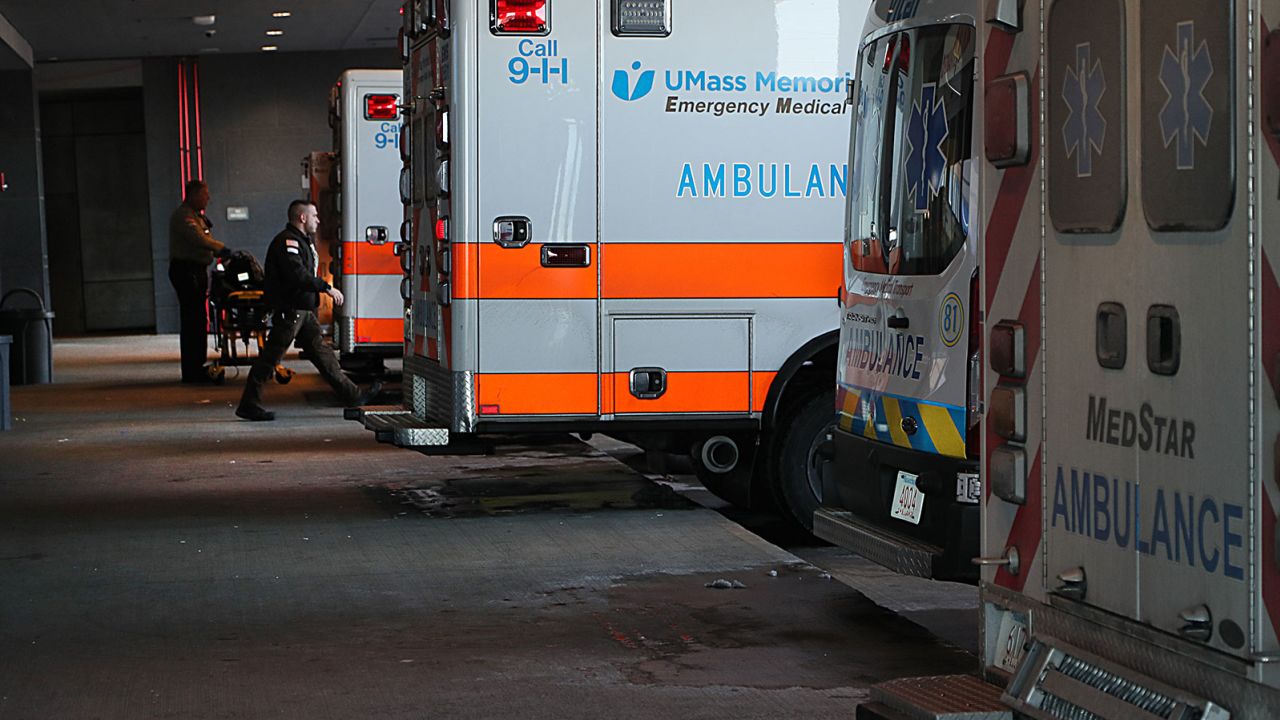 EMTs transfer and deliver patients in the busy ambulance bay at UMass Memorial Medical Center. The hospital has been operating at above its normal capacity because there is so much illness.