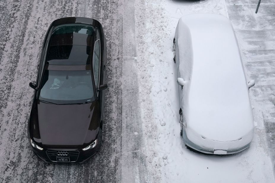 A clean car passes a snow-covered car in Des Moines, Iowa.