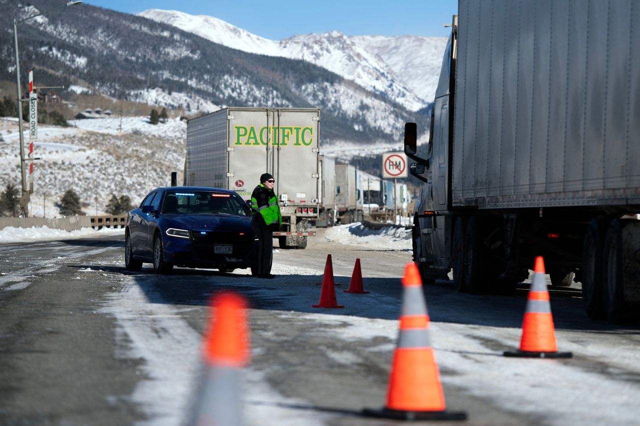 Semitrailers pull over in the eastbound lane of I-70 for drivers to put chains on their vehicles due to extreme winter driving conditions in Silverthorne, Colorado, on December 22.