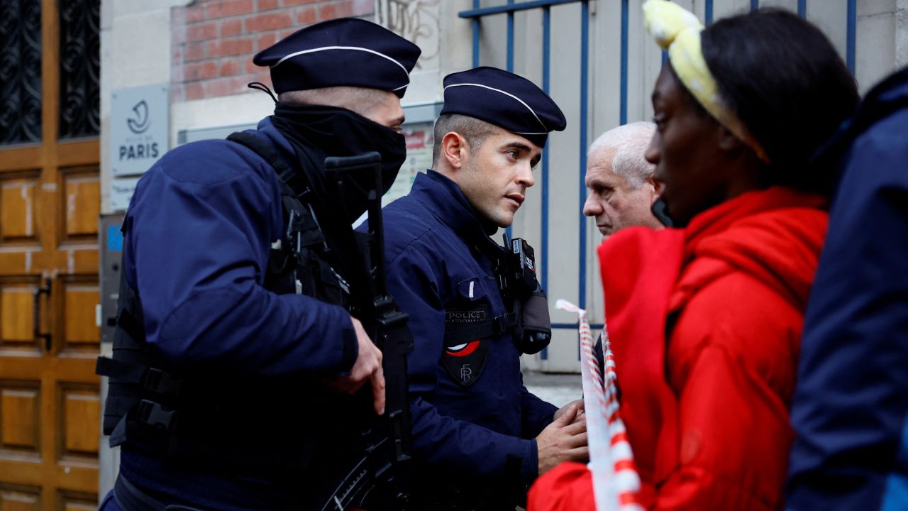 French police talk to people as they secure a street after gunshots were fired killing two people and injuring several in a central district of Paris, France, December 23, 2022.  REUTERS/Sarah Meyssonnier 