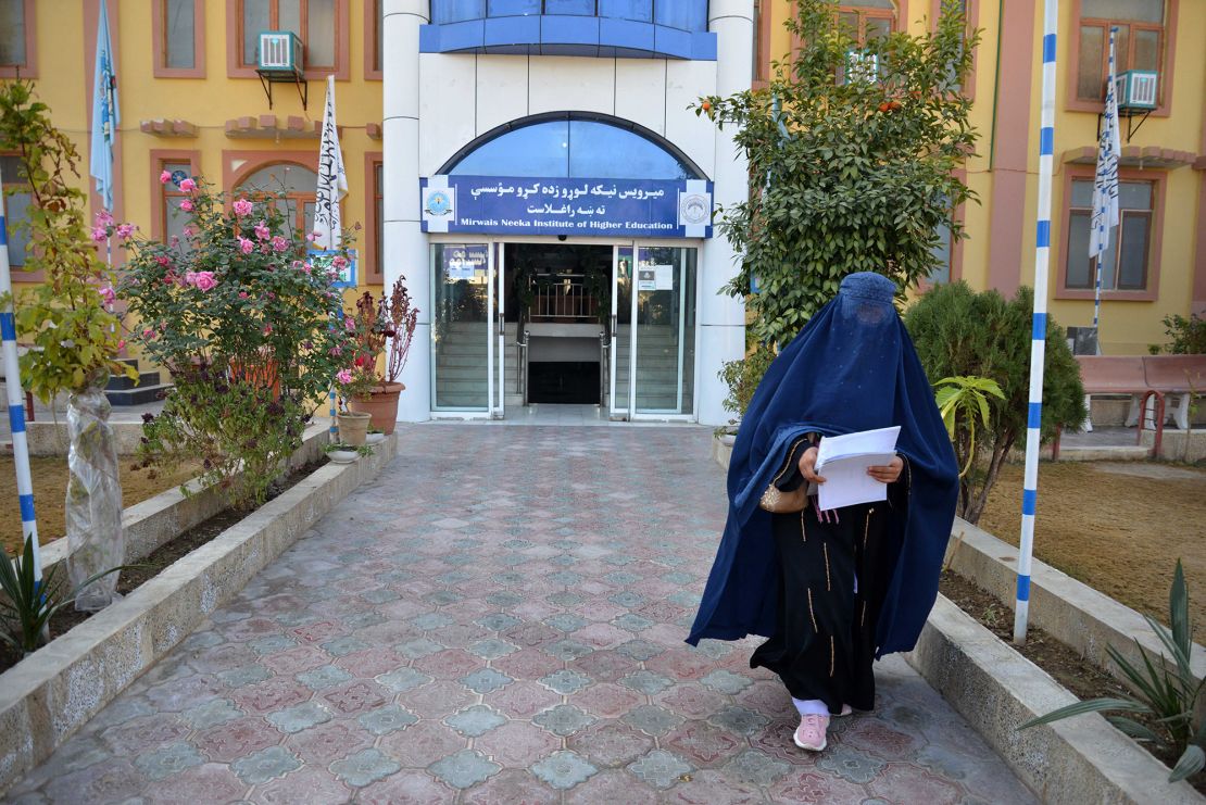 A female student walks in front of a university in Kandahar province, Afghanistan, on December 21. The Taliban have banned university education for women nationwide, p