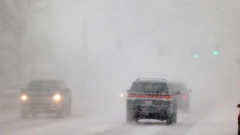 Cars drive through snowy conditions in New York's Orchard Park on Friday.