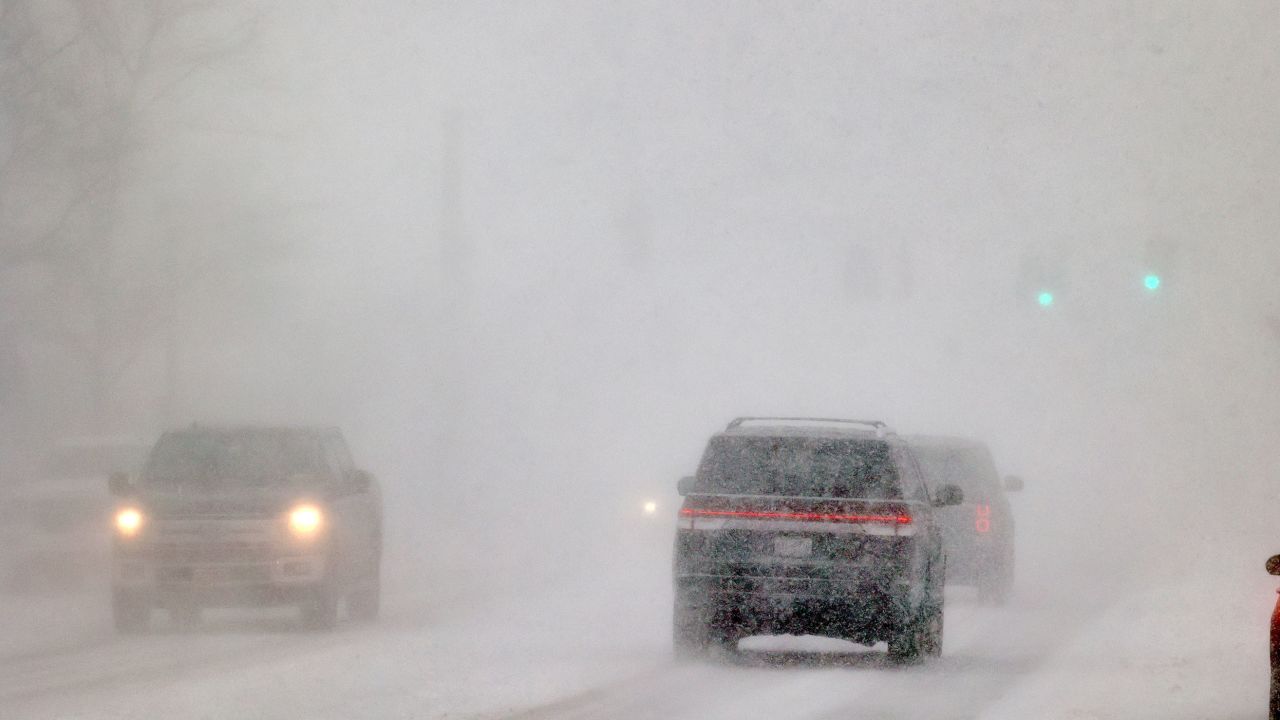 Cars drive Friday in whiteout conditions in Orchard Park, New York, south of Buffalo.