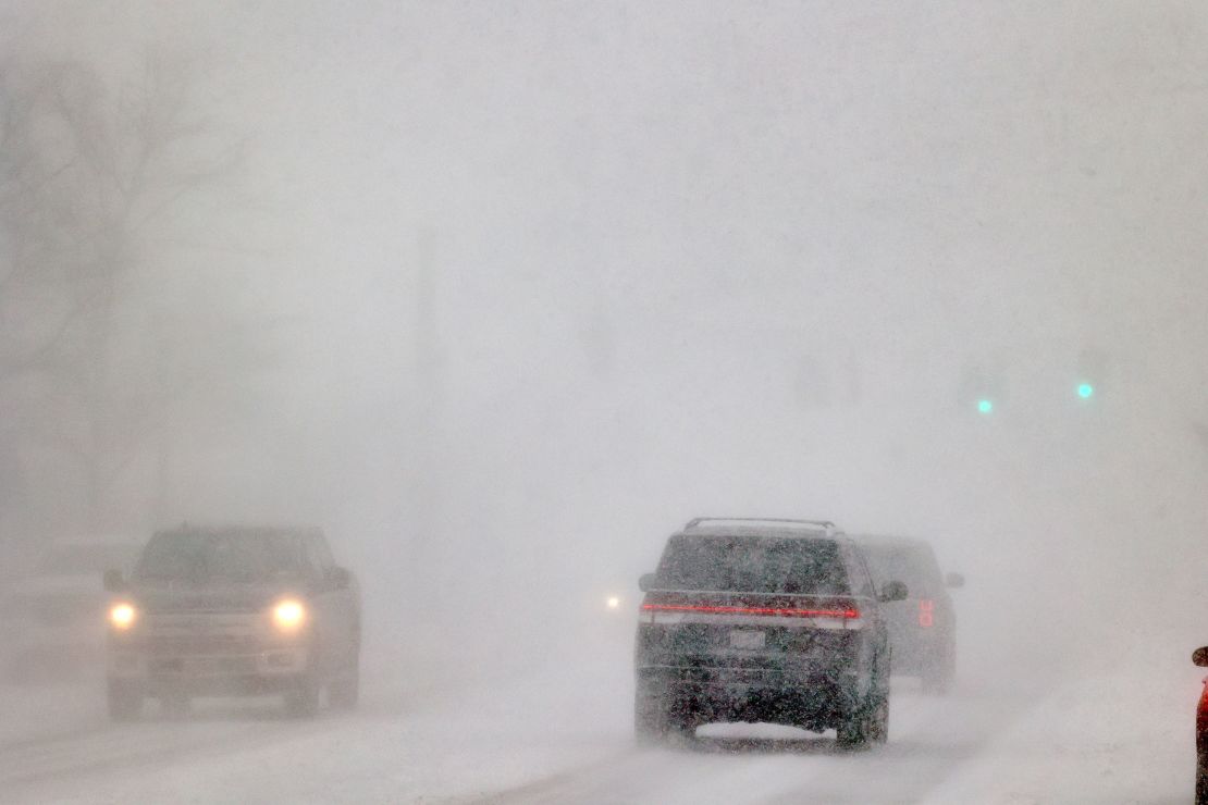Cars drive in whiteout conditions in Orchard Park, New York on Friday.