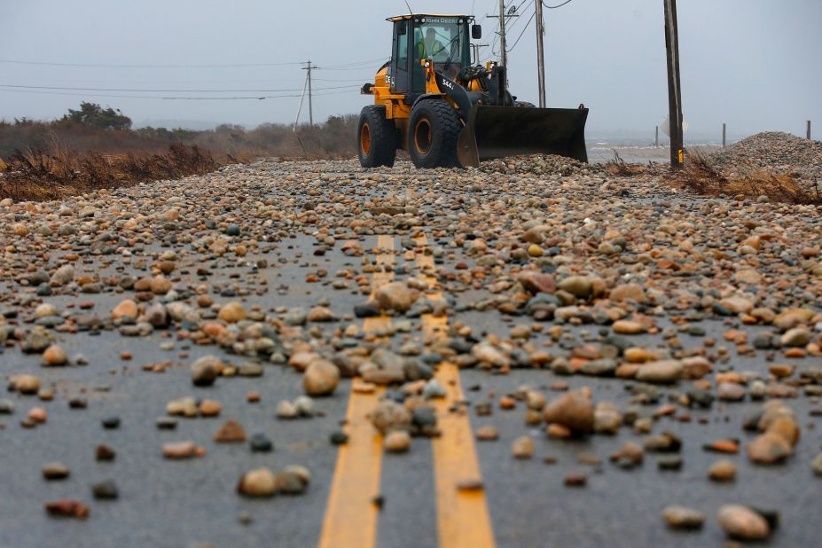 Stones are removed from a road in Westport, Massachusetts, after a storm surge made landfall, flooding many coastal areas on December 23. 