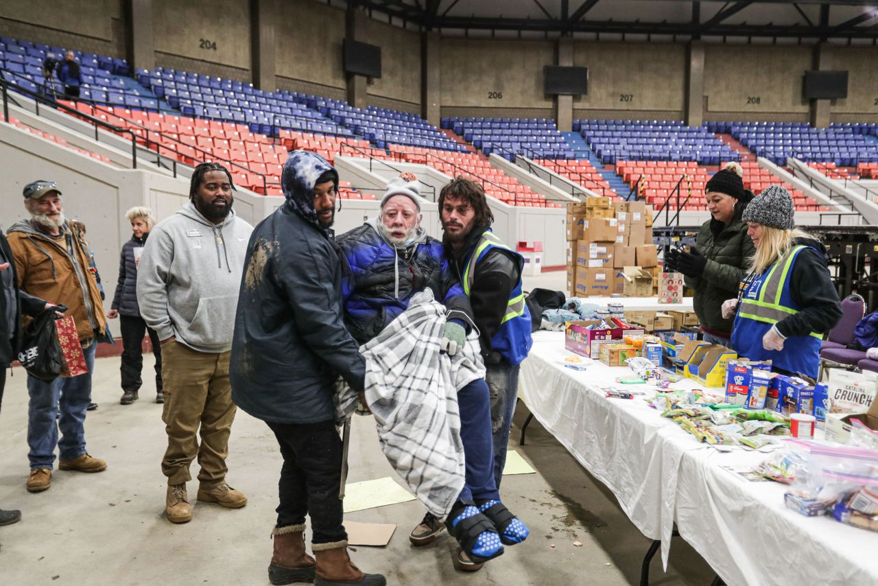 Volunteers welcome a homeless person to a shelter at Broadbent Arena in Louisville on December 23.