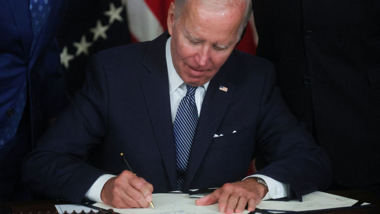 President Joe Biden signs "The Inflation Reduction Act of 2022" into law during a ceremony in the State Dining Room of the White House in August.