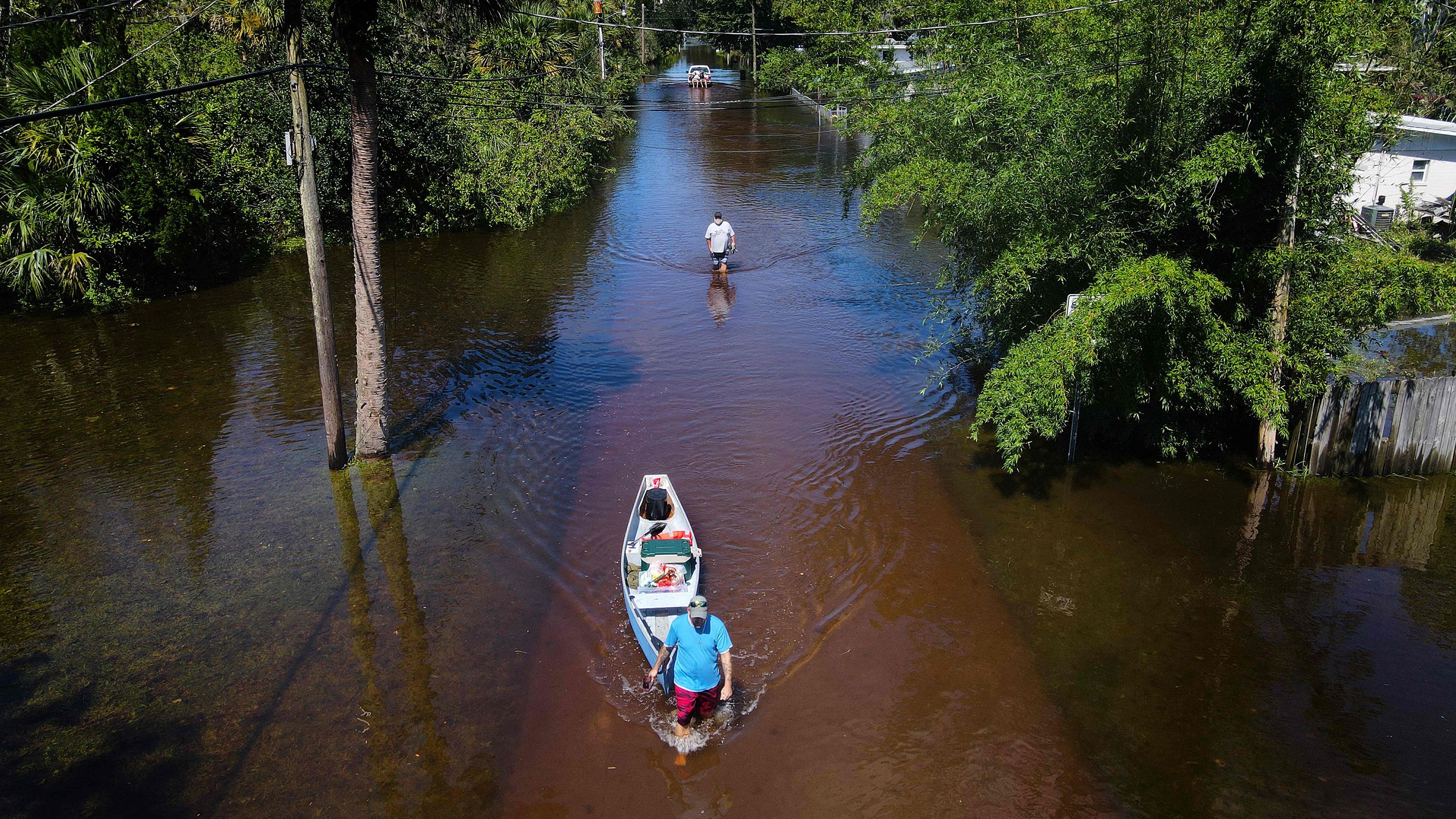 A man pulls a canoe through a flooded street of his neighborhood in New Smyrna Beach, Florida, after Hurricane Ian slammed the area in September.