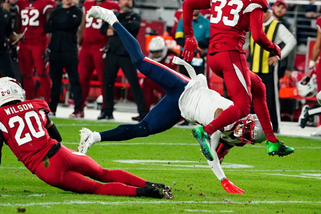 Arizona Cardinals cornerback Marco Wilson (20) tackles New England Patriots wide receiver DeVante Parker (1) during the first half of an NFL football game, Monday, Dec. 12, 2022, in Glendale, Arizona.