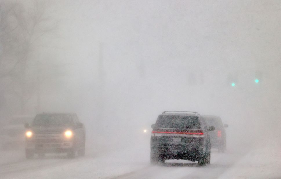 Cars drive in whiteout conditions in Orchard Park, New York, on December 23.