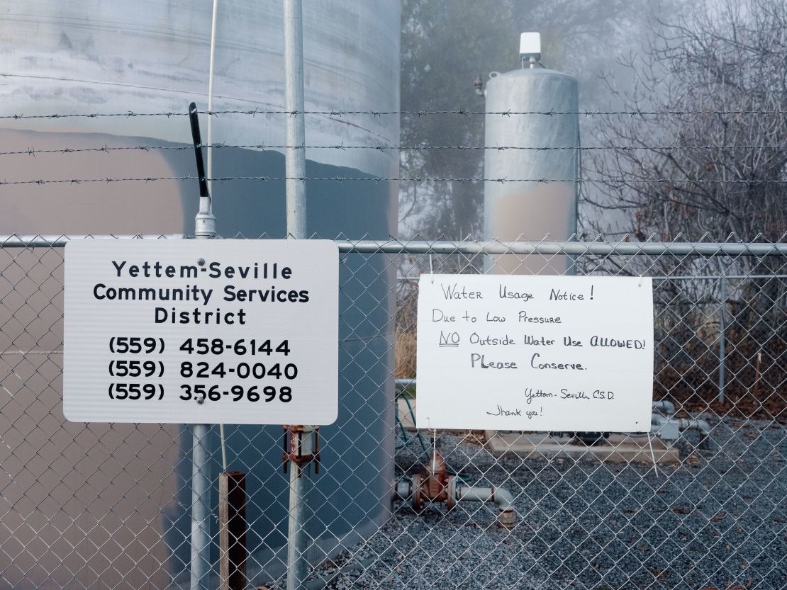 A water usage notice is posted on a fence surrounding the Yettem-Seville water storage tanks.