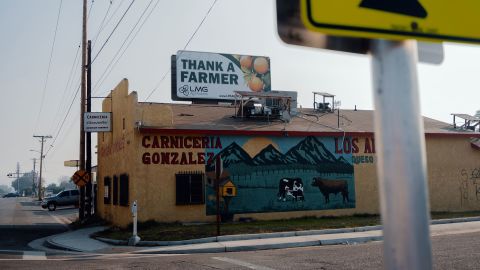 A sign reading "thank a farmer" sits atop a building in Ivanhoe, California.