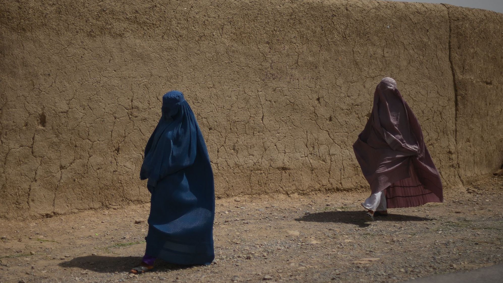 Afghan women walk alongside a road in Kandahar on July 29, 2022.