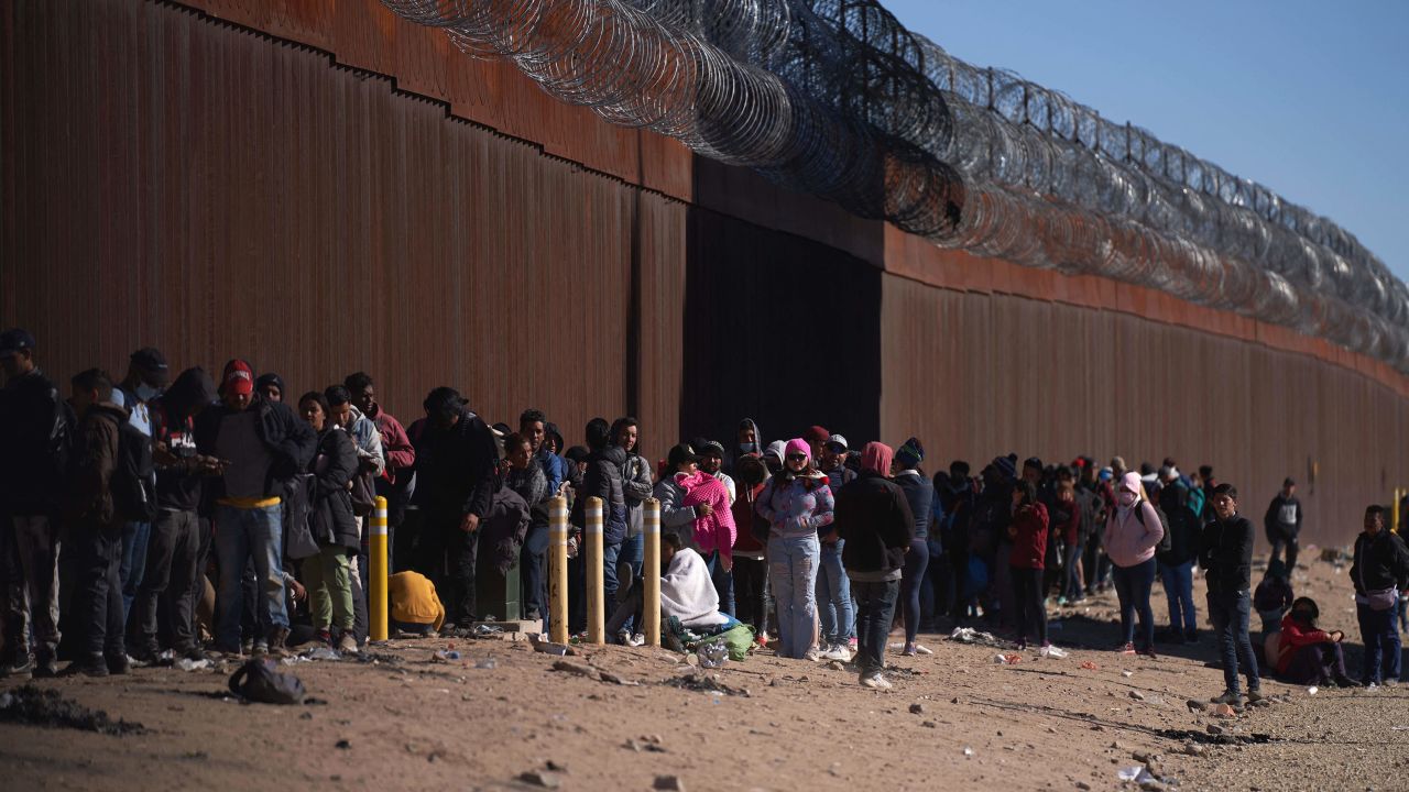 Hundreds of migrants line up to be processed by US Border Patrol under the Stanton Street Bridge after illegally entering the US, in El Paso, Texas, on December 22, 2022. 