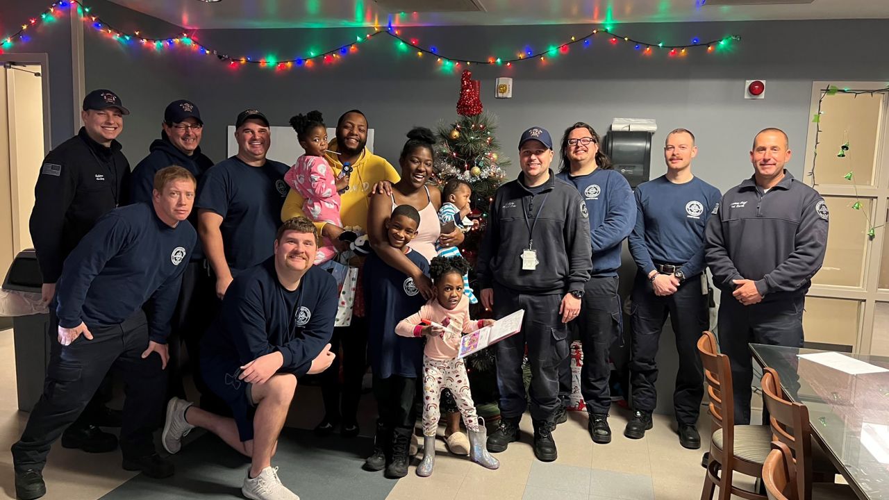 The rescued family poses with firefighters.