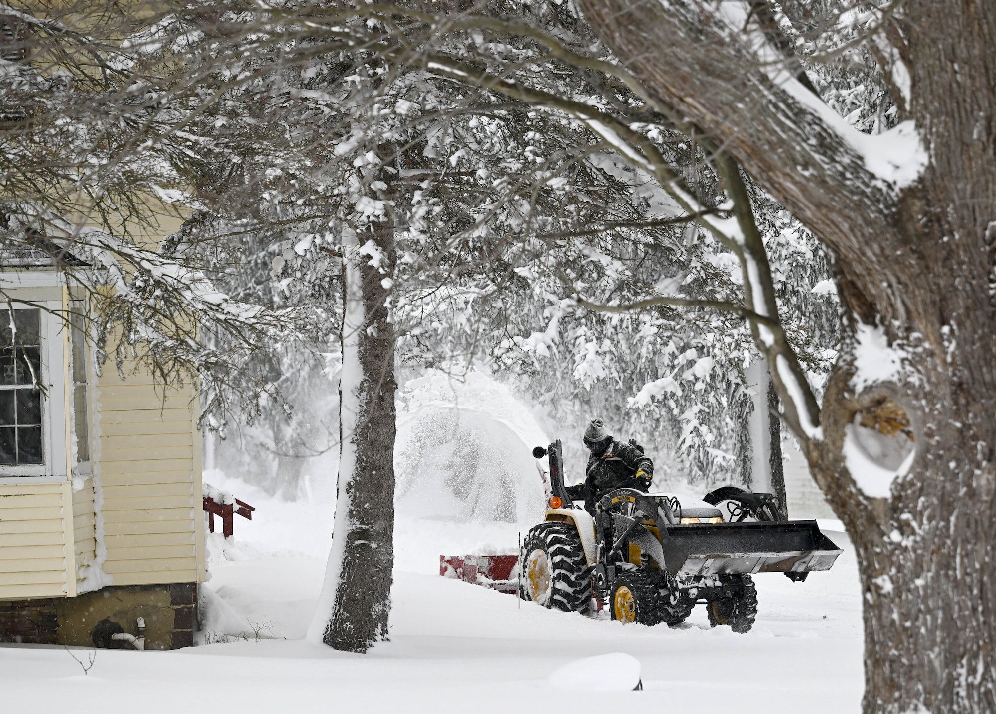 A person clears a snow-covered driveway on December 26.