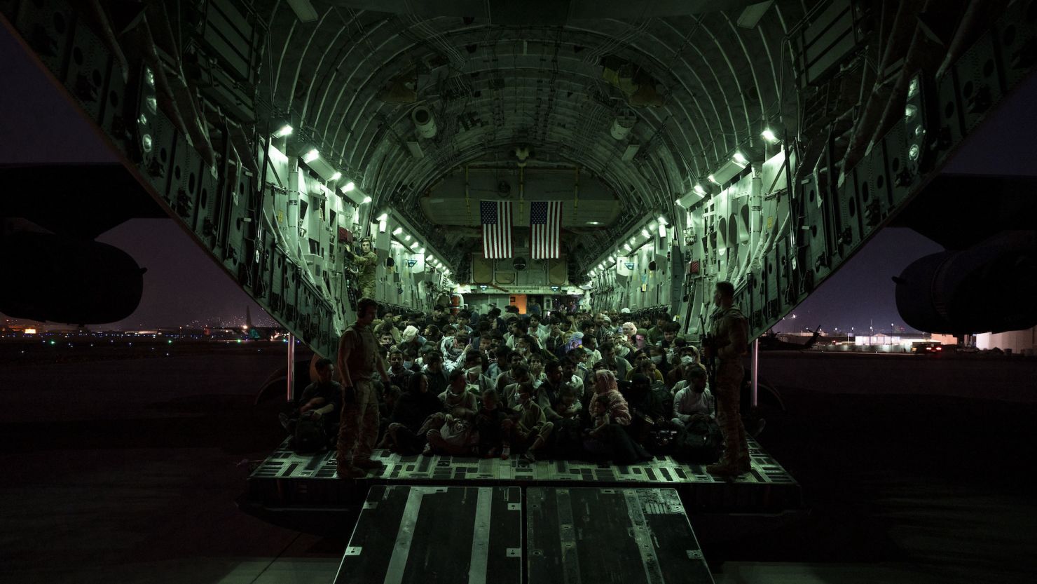 In this handout provided by the US Air Force, an air crew assigned to the 816th Expeditionary Airlift Squadron assists evacuees aboard a C-17 Globemaster III aircraft in support of the Afghanistan evacuation at Hamid Karzai International Airport on August 21, 2021, in Kabul, Afghanistan.