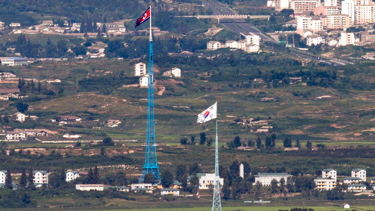Flags of North Korea, rear, and South Korea, front, flutter in the wind as pictured from the border area between two Koreas in Paju, South Korea, on Aug. 9, 2021. 