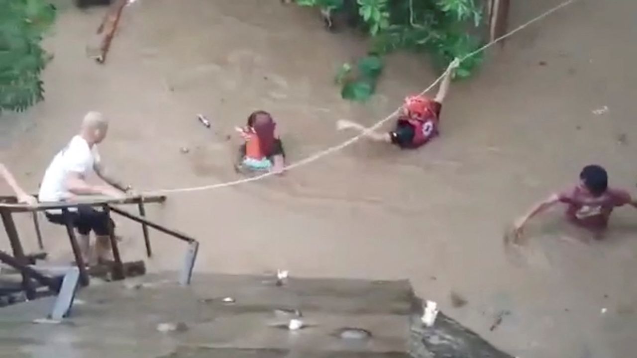 A rescuer helps people affected by floods in Gingoog city, Philippines December 25, 2022 in this screen grab obtained from a social media video. 