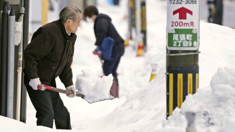 Residents shovel snow from a sidewalk in Kanazawa, Ishikawa Prefecture, central Japan, on December 24, 2022.