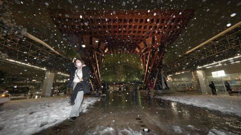 A pedestrian walks in the snow in front of JR Kanazawa Station in Ishikawa prefecture, central Japan, on December 23, 2022.