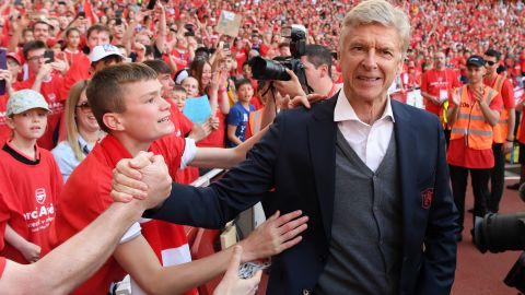Wenger shakes hands with a fan after the Premier League match between Arsenal and Burnley at the Emirates Stadium on May 6, 2018.