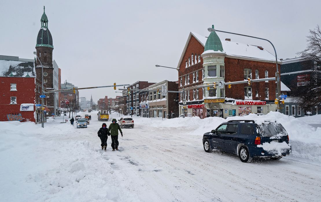 People and vehicles move about Monday on Main Street in Buffalo.
