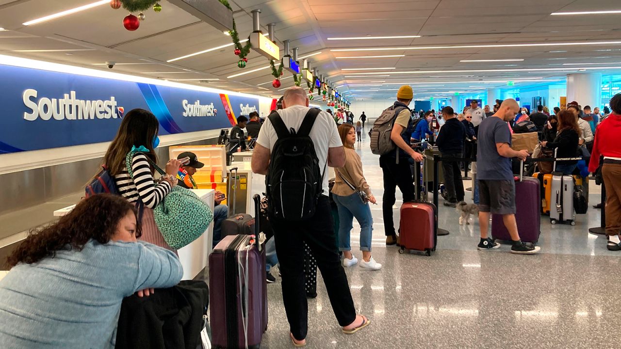 Travelers wait at a Southwest Airlines baggage counter to retrieve their bags after canceled flights at Los Angeles International Airport, Monday, December 26, 2022, in Los Angeles. 