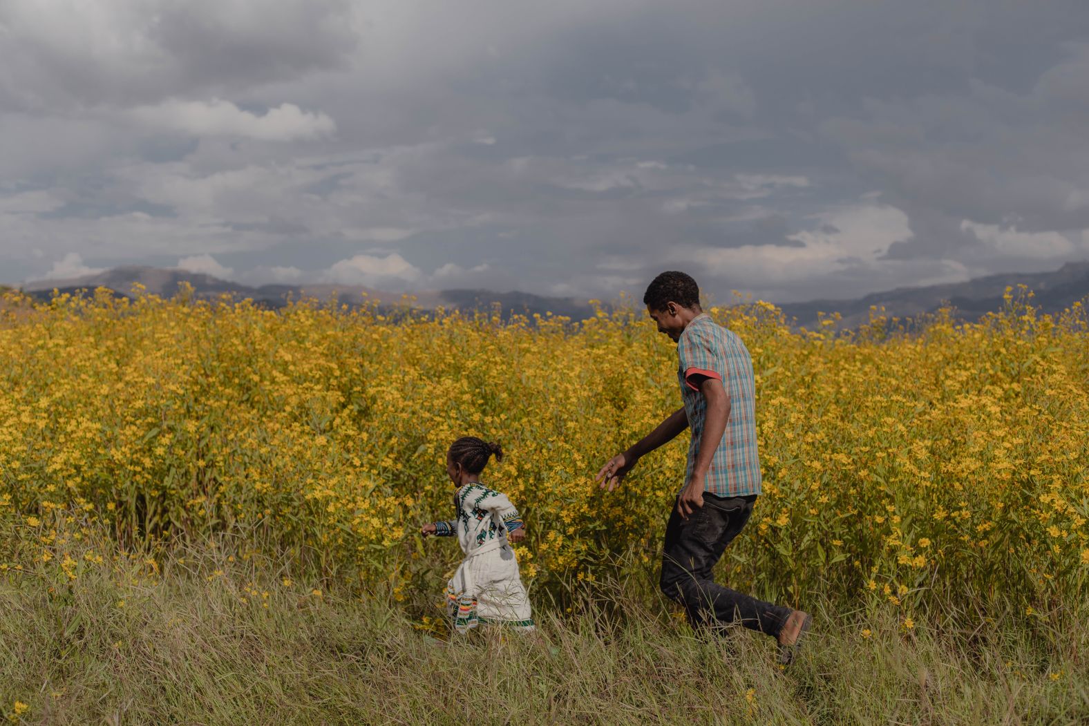 <strong>From </strong><a href="https://www.marthinolly.com/" target="_blank" target="_blank"><strong>Martha Tadesse</strong></a><strong>, a photographer based in Addis Ababa, Ethiopia: "</strong>Mar'eshet plays with his 4-year-old daughter, Edilawit, outside their home in Maksegnit, in Gondar, Ethiopia. I met Sifrash, Mar'eshet's wife, during an assignment on newborn care, and I was able to witness Edilawit's birth.<br /><br />"There have been several gruesome images of <a href="https://www.cnn.com/2022/11/03/africa/ethiopia-civil-war-truce-explainer-intl/index.html" target="_blank">Ethiopia's civil war</a> and conflicts in the past two years. Every day, we woke up to another terrible story and photograph. The Adey Abeba flower in this photograph is native to Ethiopia and blooms in September, just before the Ethiopian New Year begins. The flower represents a new beginning, and yellow is frequently connected with peace.<br /><br />"It made me so joyful to see this lovely moment between a father and his daughter. As the flower represents new beginnings and peace, I hope we wake up to good news and cheerful stories all around us."