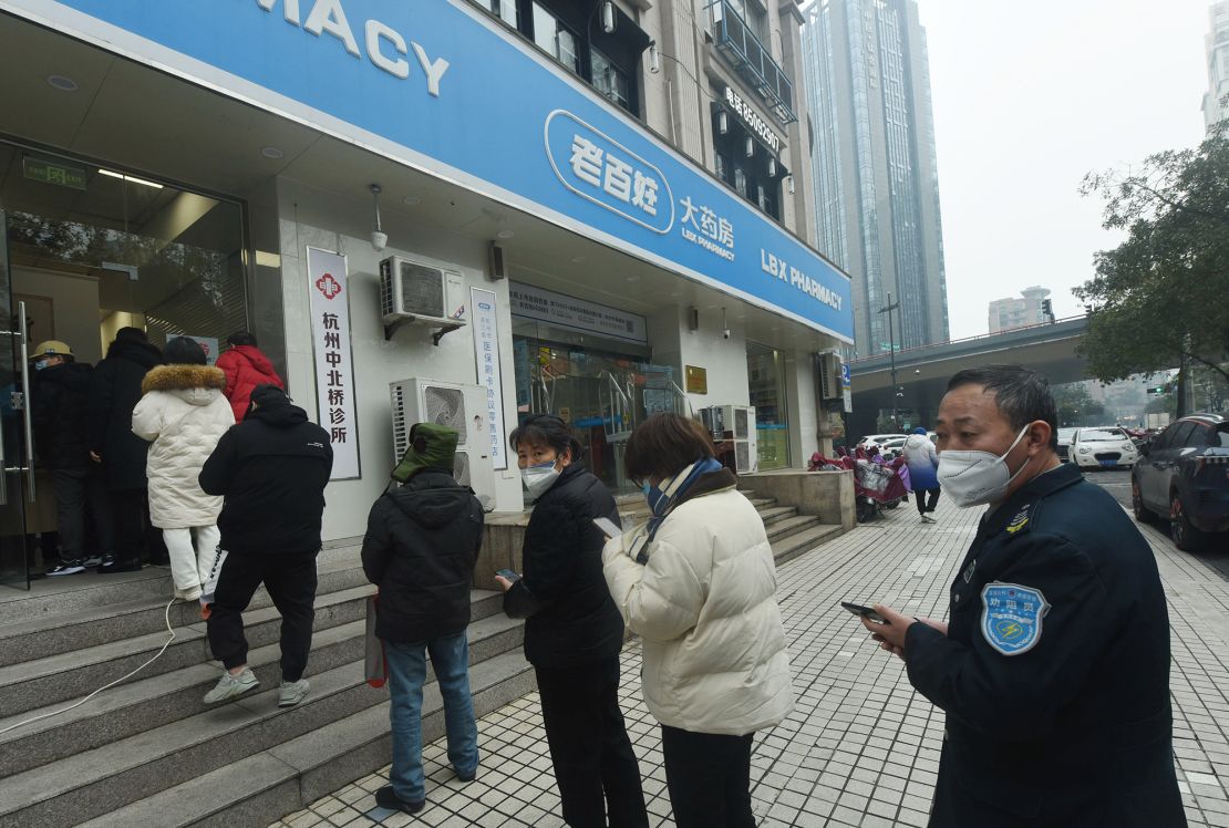 People line up to receive free ibuprofen tablets for reducing fever at the flagship store of a national drugstore chain in Hangzhou, east China's Zhejiang province, Dec 28, 2022. 