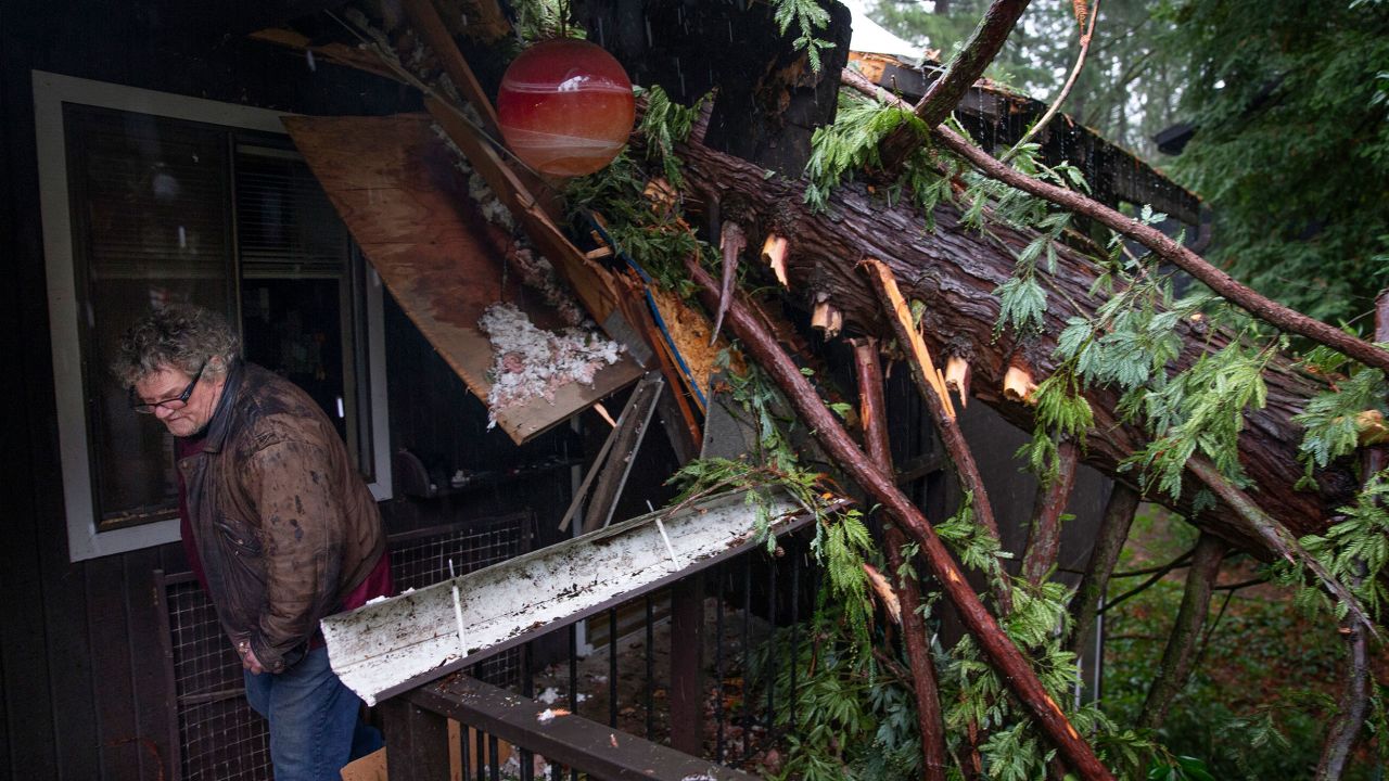 Bill Lance leaves his Eugene, Oregon, home Tuesday after a windstorm blew a tree onto the condominium's roof.