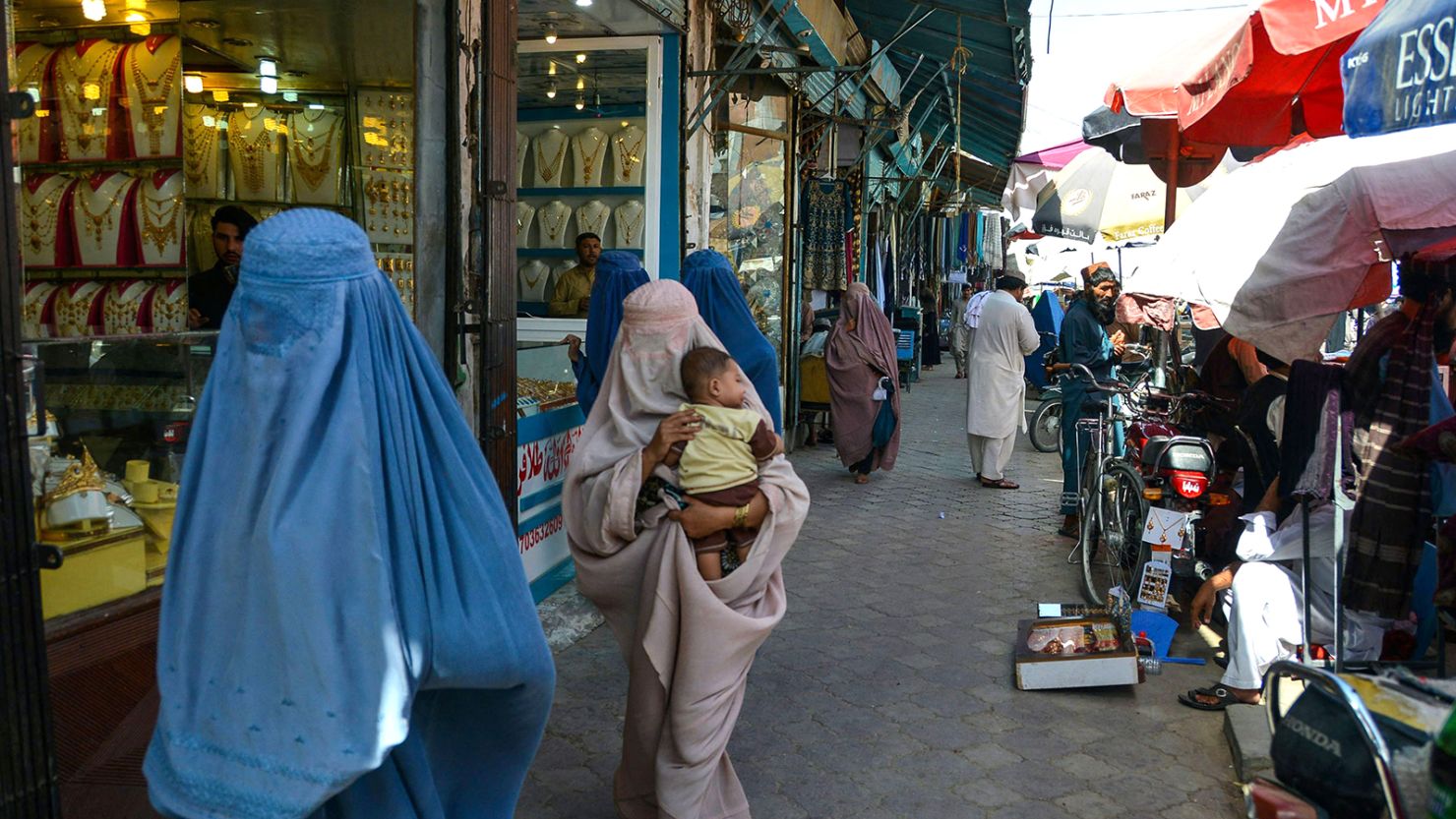 Afghan women walk along a market at Chaharso square in Kandahar on August 4, 2022.