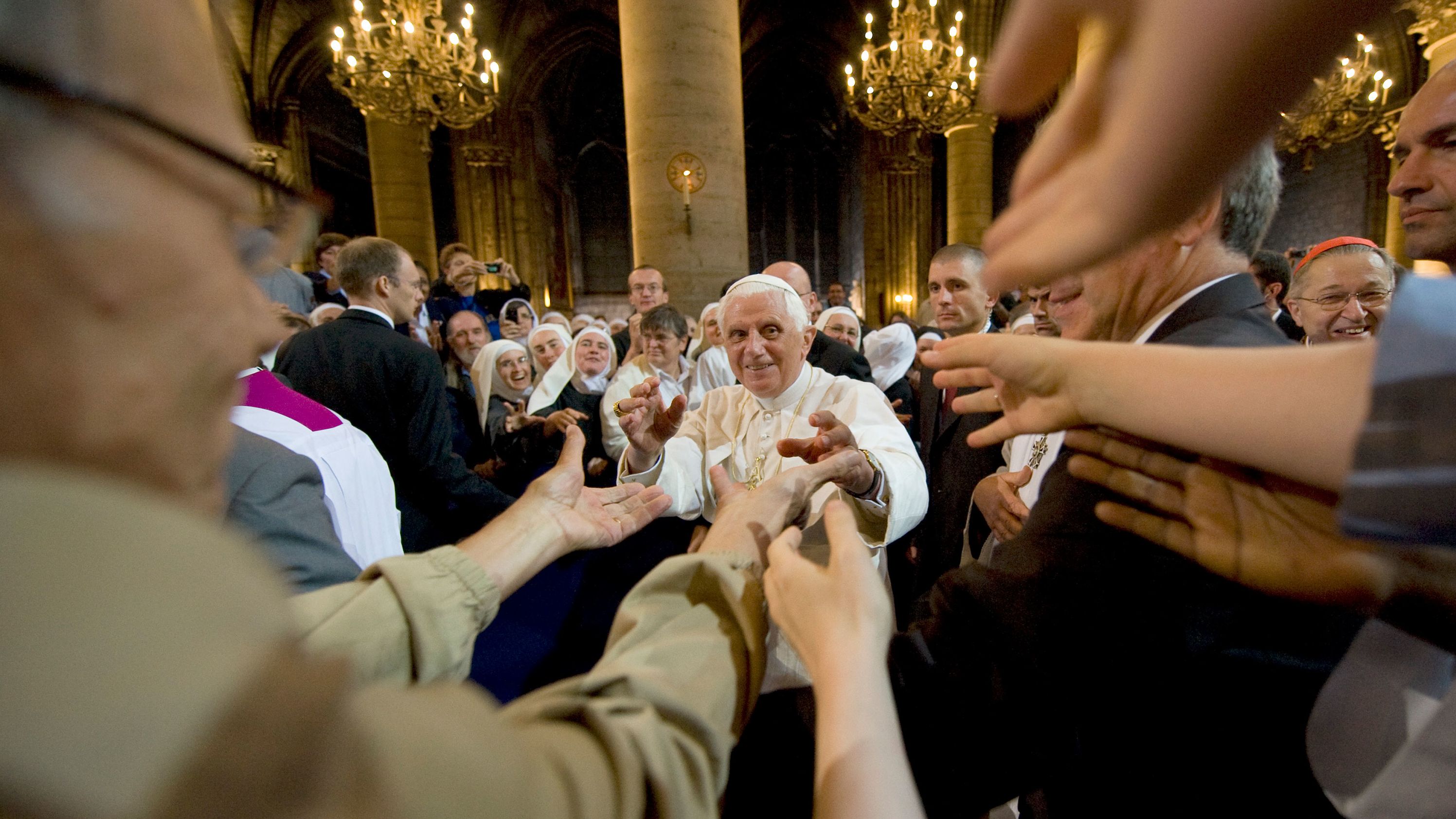 Arms stretch out to Benedict as he leaves Paris' Notre Dame Cathedral in September 2008.