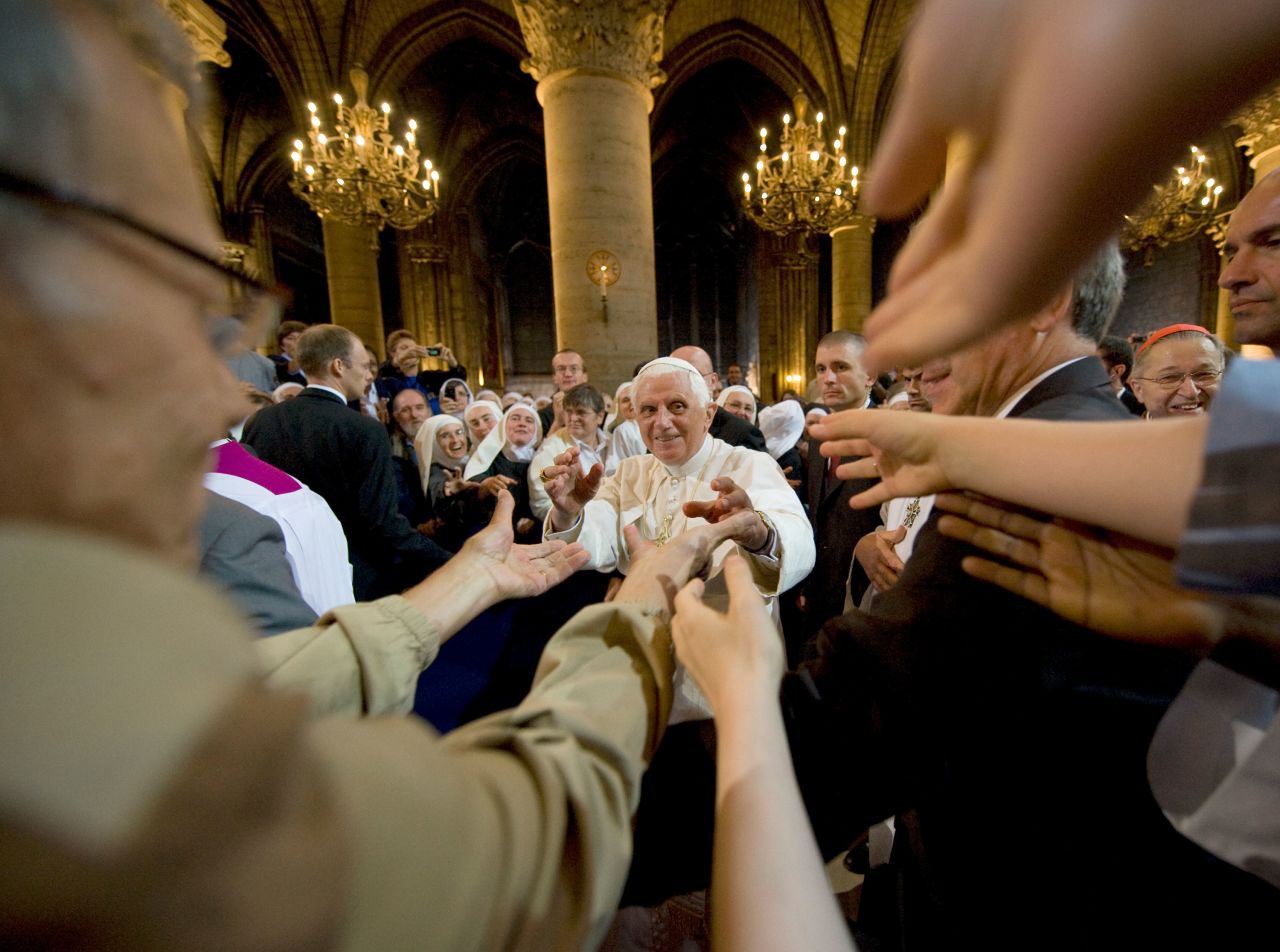 Arms stretch out to Benedict as he leaves Paris' Notre Dame Cathedral in September 2008.