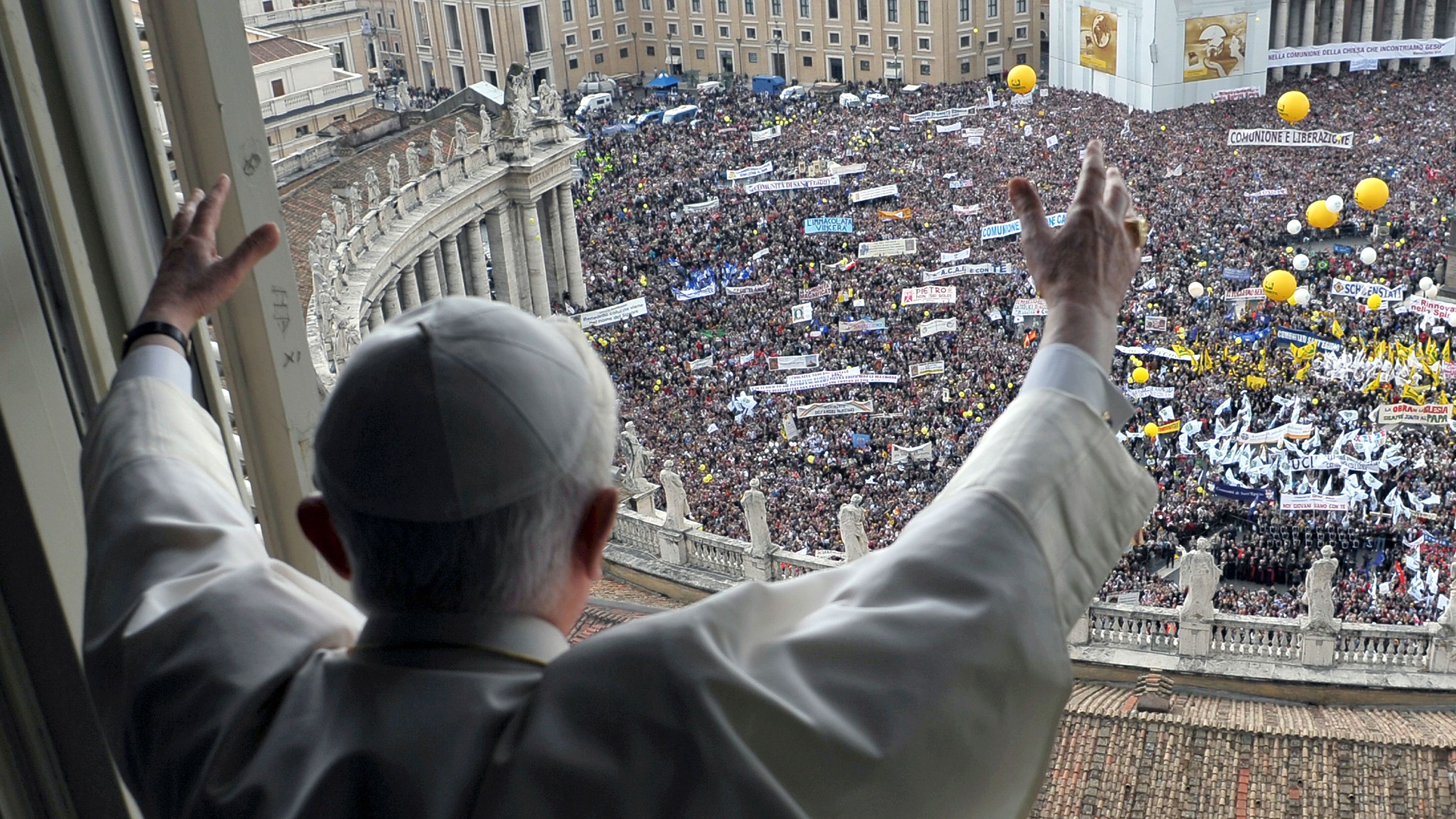 Benedict waves to the crowd gathered below St. Peter's Square during a weekly Angelus blessing in May 2010.