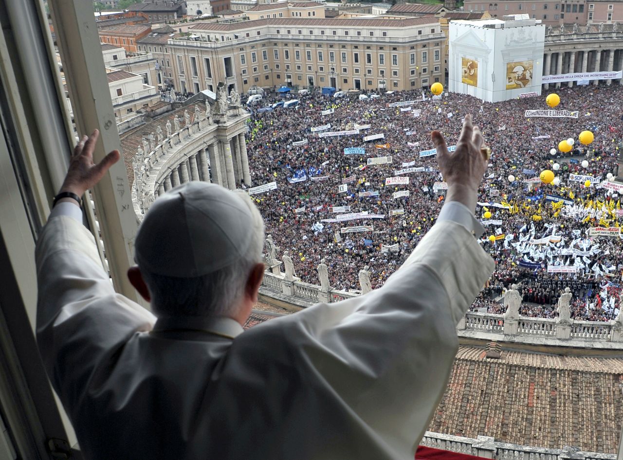 Benedict waves to the crowd gathered below St. Peter's Square during a weekly Angelus blessing in May 2010.