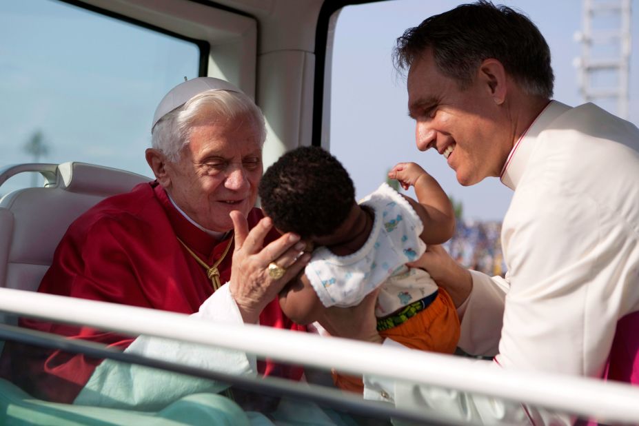 Benedict prepares to kiss a baby as he arrives for a Mass in Cotonou, Benin, in November 2011.