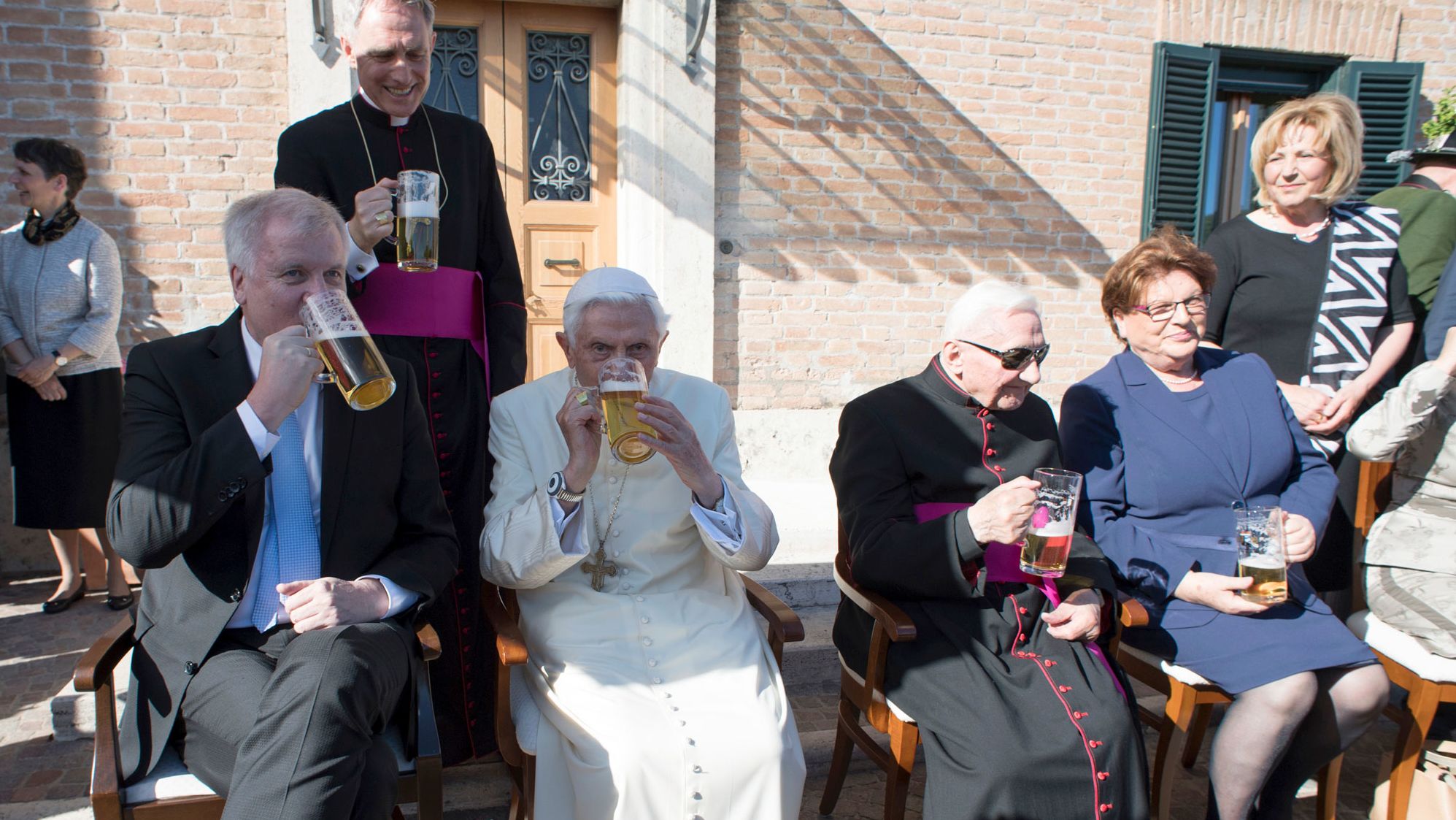 Benedict, seated second from left, has a glass of beer on his 90th birthday in 2017.