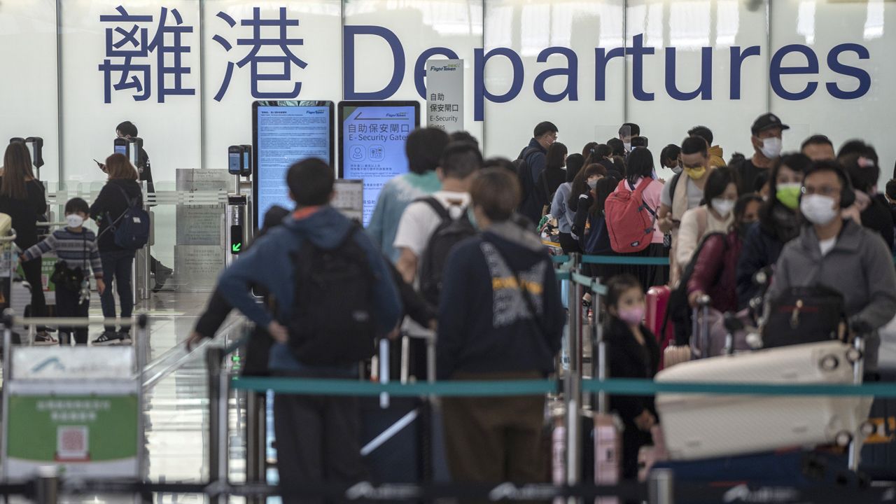 Travelers waiting in line to check in at the Hong Kong International Airport on December 20, 2022.